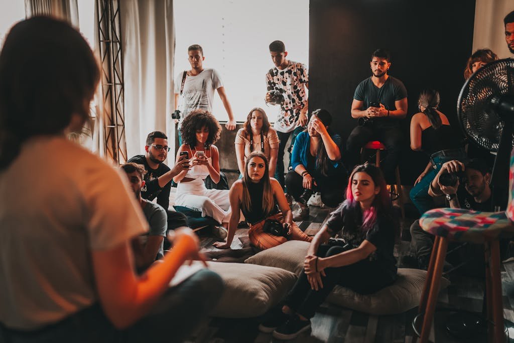 Group of multiethnic people gathering around female speaker in studio