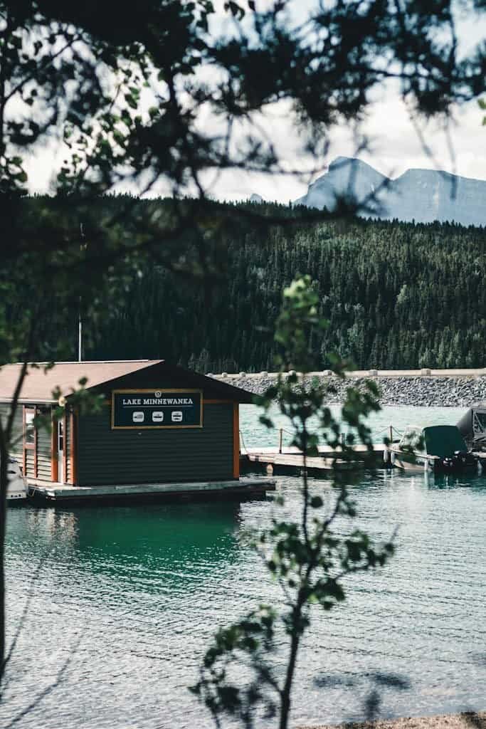 Banff National Park Itinerary - Lake Minnewanka surrounded by forested mountains in Banff, Alberta.
